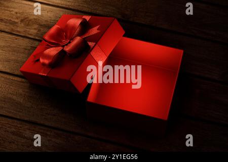 Red christmas gift on vintage wooden table from above. Open present box for xmas and new year holiday. Empty giftbox for product placement montage moc Stock Photo
