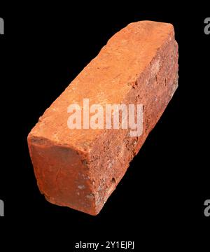 Side view of old red or orange brick is isolated on black background. Stock Photo