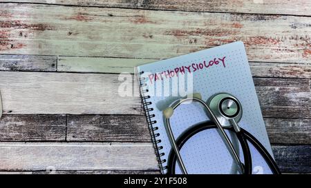 Concept of Pathophysiolgy write on book isolated on Wooden Table. Stock Photo