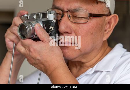 London. UK- 09.03.2024. An senior man using a Leica vintage classic camera. Stock Photo
