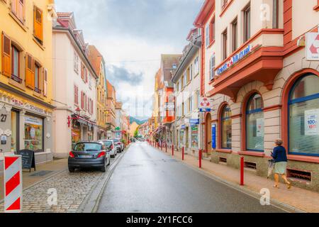 The picturesque colorful Grand Rue street with sidewalk cafes and shops in the historic old town of Munster, France, in the Alsace wine region. Stock Photo