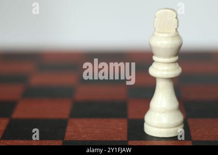 White King Chess Piece on wooden board with white background Stock Photo