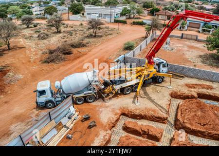 aerial view, concrete pump crane, concrete pumping services truck pouring liquid concrete Stock Photo