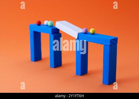 Group of separate spheres in interrupted step of bridge made of wooden figures Stock Photo