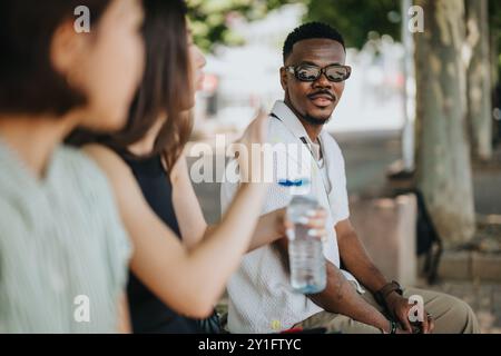 Multicultural businesspeople having an outdoor meeting in the city, discussing business ideas together Stock Photo