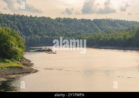 Peaceful lake surrounded by wooded hills with slightly cloudy sky, Rappbodetalsperre, Harz Mountains, Germany, Europe Stock Photo