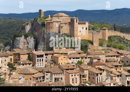 Historic castle perched above stone houses in a medieval village on a rock, collegiate church on the hill, Colegiata de Santa Maria la Mayor, Alquez Stock Photo