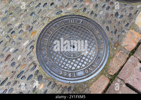 Manhole cover installed in Alquezar in 1966, surrounded by uneven paving stones, manhole cover, manhole cover, Alquezar, Alquezar, Huesca, Aragon, A Stock Photo