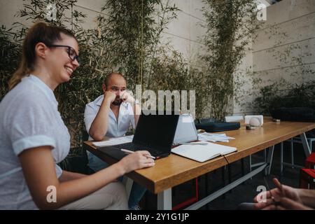 Young business entrepreneurs strategizing and collaborating on a project in an outdoor workspace Stock Photo