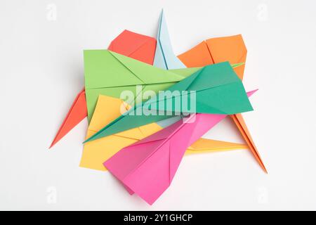 Paper, creative and art with plane in studio for colorful, invention and design of handmade craft. Geometric, shape and pile with jet by white Stock Photo