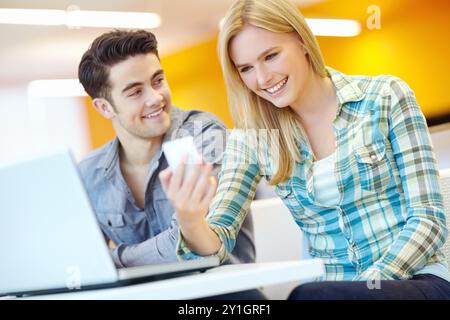 App, laptop and phone with student friends in library on campus of college or university for development. Computer, education and social media with Stock Photo