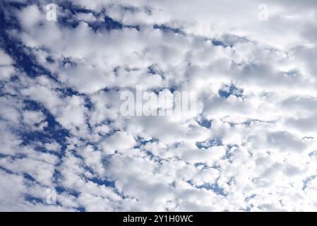 Scenic view of a partly cloudy sky with scattered fluffy white clouds in a blue sky. Stock Photo