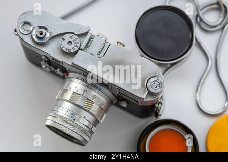 A classic vintage camera with lens cap and filter isolated in a white background. Stock Photo