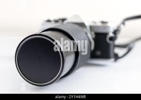 A legacy macro lens attached to a vintage SLR photography camera, isolated in white. Stock Photo