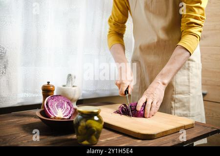 Unrecognizable man cutting purple cabbage in the kitchen Stock Photo