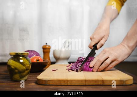 Unrecognizable man cutting red cabbage in the kitchen Stock Photo