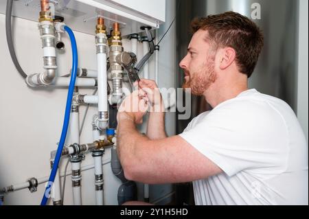 Technician checks the operation of a heat pump in a house. Stock Photo