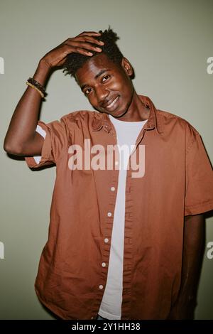 Black man touching his black hair while posing for portrait Stock Photo
