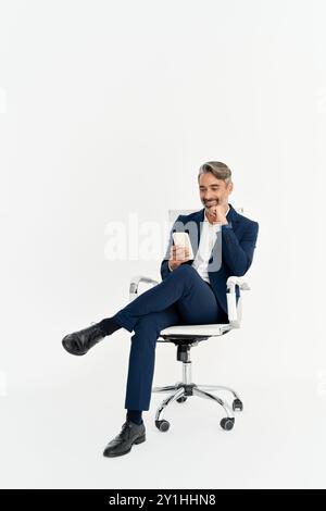Older business man using phone sitting in office chair isolated on white. Stock Photo