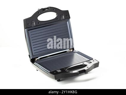 Black modern sandwich maker on a white background, isolate, close-up. Making toast and sandwiches, technology Stock Photo