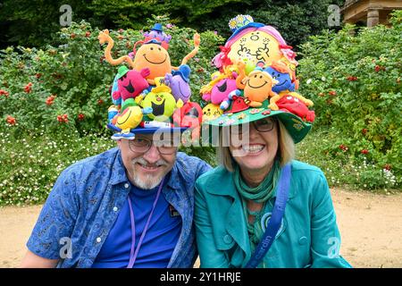 Bridport, Dorset, UK. 7th September 2024.  Hundreds of people wearing creatively decorated hats attend the annual Bridport Hat Festival at Bridport in Dorset.  A couple wearing Mr Men hats.  Picture Credit: Graham Hunt/Alamy Live News Stock Photo