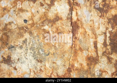 Close up of a white, cream, gray, and reddish brown rust colored rock. Large stone texture background with copy space. Stock Photo