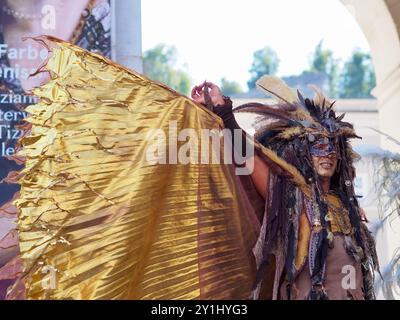 Salzburg, Austria - 31 Aug, 2024: An individual dressed in elaborate festive costumes with large feathered headpieces and ornate accessories posing in Stock Photo