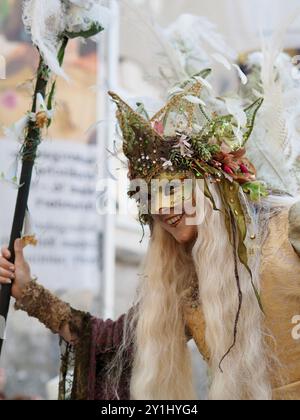 Salzburg, Austria - 31 Aug, 2024: An individual dressed in elaborate festive costumes with large feathered headpieces and ornate accessories posing in Stock Photo