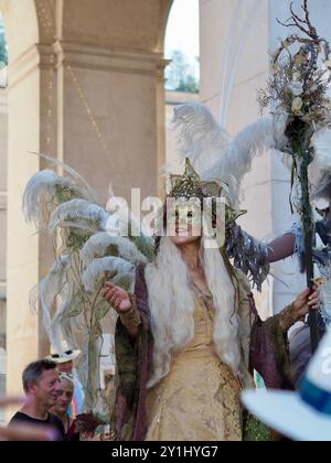 Salzburg, Austria - 31 Aug, 2024: An individual dressed in elaborate festive costumes with large feathered headpieces and ornate accessories posing in Stock Photo