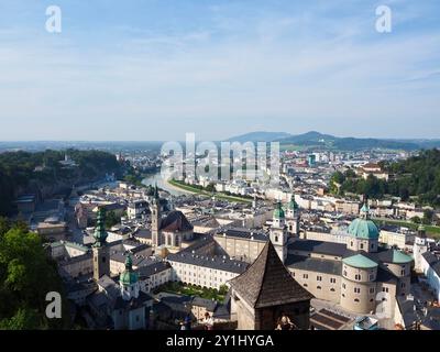 Salzburg, Austria - 31 Aug, 2024: This image showcases a panoramic view of a cityscape with rivers running through it, prominent churches, and various Stock Photo