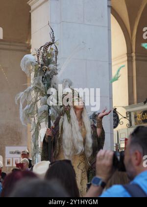 Salzburg, Austria - 31 Aug, 2024: An individual dressed in elaborate festive costumes with large feathered headpieces and ornate accessories posing in Stock Photo