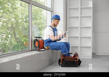 Male contractor writing on clipboard in room Stock Photo