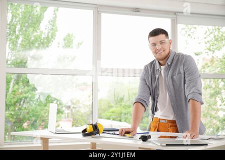Male contractor working at table in room Stock Photo