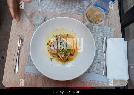 Topdown view of salted codfish in orange sauce, a typical spanish food, served for dinner in Bilbao in the autonomous community of the basque country: Stock Photo