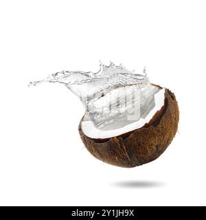 Fresh coconut water splashing from nut in air on white background Stock Photo