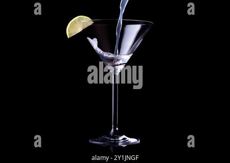 margarita is poured into a Martini glass. Isolated on black. Empty space for text Stock Photo