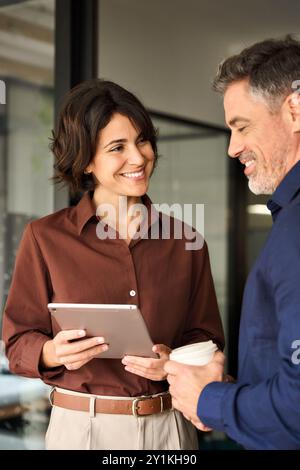 Happy executives team two business people working talking standing in office. Stock Photo