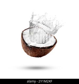 Fresh coconut water splashing from nut in air on white background Stock Photo
