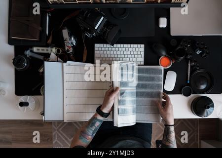Photographer reviewing negatives at a modern desk setup Stock Photo