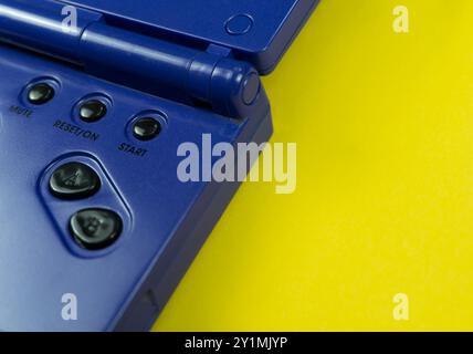 Vintage gaming controller with directional and selection buttons set against a bright yellow background Stock Photo