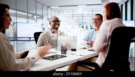 Group Of Multi Ethnic Businesspeople Discussing Together In Office Stock Photo