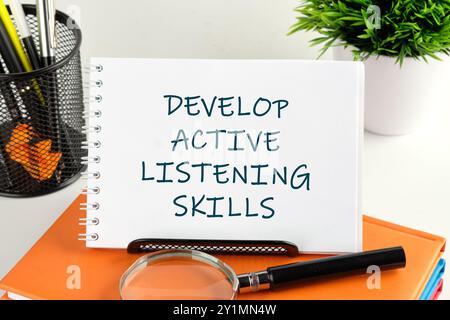 Business and Develop active listening skills concept. DEVELOP ACTIVE LISTENING SKILLS handwritten text in a notebook, notepad Stock Photo