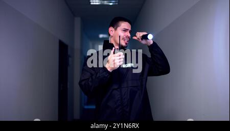 Male Security Guard With Flashlight At Night Stock Photo