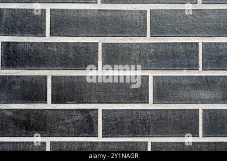 Background from a clinkered wall with black bricks Stock Photo