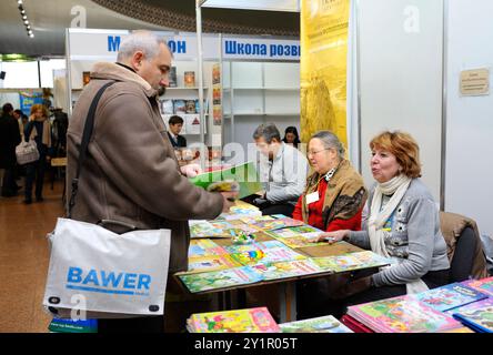 Customers standing in front of a bookshop counter and reading new published books. Book Fair Book contracts . December 14, 2017. Kiev, Ukraine Stock Photo