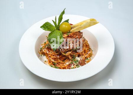 Delicious Italian pasta with spaghetti alla bolognese in tomato sauce in a white plate. Delicious dinner at the restaurant. Stock Photo