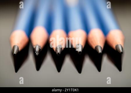 A close-up view of sharpened blue pencils arranged neatly, showcasing their tips, perfect for artistic representation, school projects, and office sup Stock Photo
