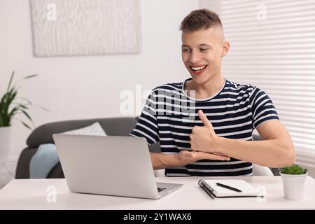 Young man using sign language during video call indoors Stock Photo