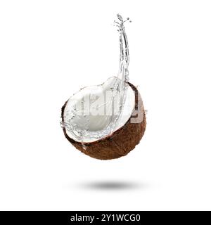 Fresh coconut water splashing from nut in air on white background Stock Photo