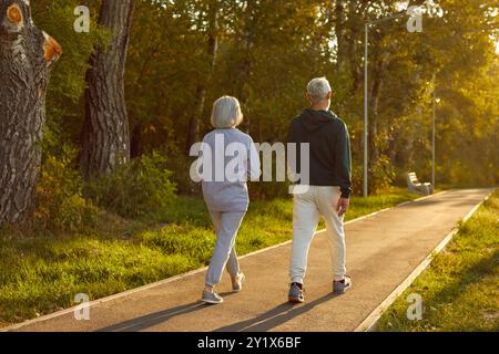 Senior active couple, old spouses enjoy walking outdoor, sporty fit wife and husband going to walk Stock Photo
